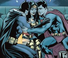 superman and wonder woman hugging on the couch in front of a man with his arm around her