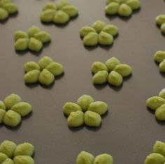 green candies are lined up on a baking sheet