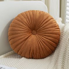 a round pillow sitting on top of a white couch