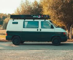 the van is parked on the side of the road with its roof rack mounted to it's roof