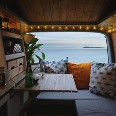 the inside of a camper with lights strung over it