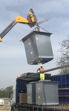 a crane is lifting a container onto the back of a truck