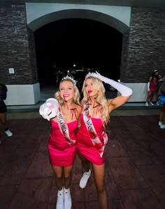 two women dressed in pink posing for the camera