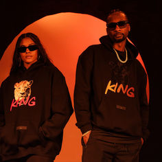 two people wearing matching sweatshirts and sunglasses