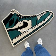 a pair of feet standing next to a rug with a shoe on it