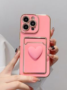 a woman holding up a pink phone case with a heart on the front and sides