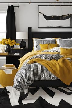 a bedroom with yellow and black bedding in the middle, white rugs on the floor