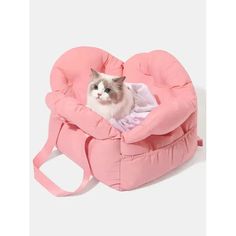 a cat sitting in a pink heart shaped chair