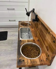 a wooden bench with two bowls filled with dog food on it and water running from the faucet