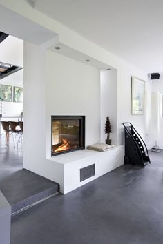 a modern living room with a fire place in the center and stairs leading up to it