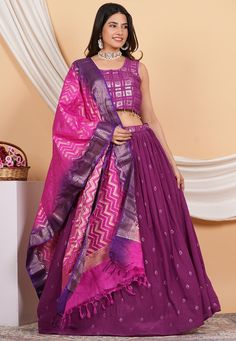 Readymade Faux Crepe Lehenga in Purple Color. This attire with Cotton Lining is Enhanced with Belt, Bag, Tassels, Resham, Zari, Sequins, Mirror and Beads Work. Available with a Faux Georgette Padded Sleeveless Choli in Purple and a Pure Banarasi Silk Dupatta in Pink and Purple. Crafted in Round Neck. The Choli and Lehenga Length are 15 and 42 inches respectively. Do note: 1.)Accessories shown in the image are for presentation purposes only. 2.)Slight variation in actual color vs. image is possib Festive Purple Sharara With Motifs, Purple Semi-stitched Sharara With Motifs, Semi-stitched Purple Sharara With Motifs, Purple Motif Sharara For Diwali, Diwali Purple Sharara With Motifs, Diwali Purple Motif Sharara, Purple Sets With Motifs For Diwali, Purple Motif Sets For Diwali, Purple Diwali Sets With Motifs