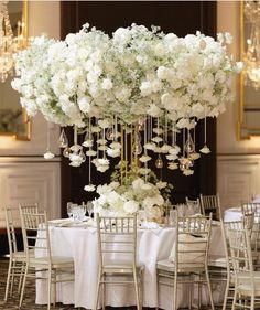 an elegant table with white flowers and chandelier