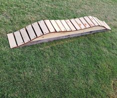 a piece of wood that is laying in the grass with some boards attached to it