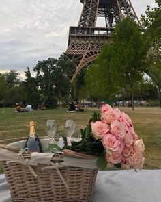 a picnic table with flowers and champagne in front of the eiffel tower