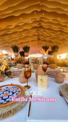 a table with plates and place settings on it in a room that looks like a tent