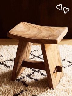 a wooden stool sitting on top of a rug