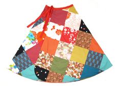 a colorful patchwork dress hanging on a white wall