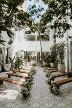 an empty courtyard with benches and potted plants