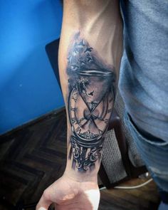 a man's arm with a clock tattoo on it