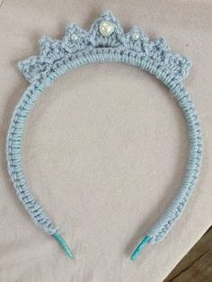 a crocheted headband with pearls on it sitting on top of a table