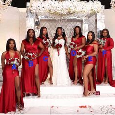 a group of women standing next to each other in front of a white wall with flowers