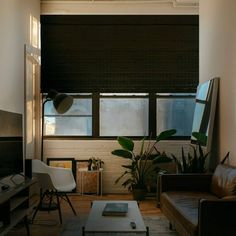 a living room filled with furniture and a flat screen tv mounted to the wall next to a window