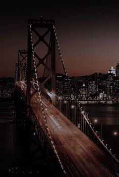 the city lights shine brightly over the bay bridge