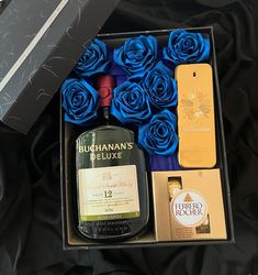 a bottle of booze and blue roses in a gift box