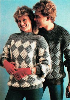 a man and woman standing next to each other wearing sweaters with checkered patterns