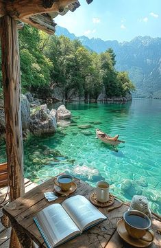 an open book sitting on top of a wooden table next to a boat in the water