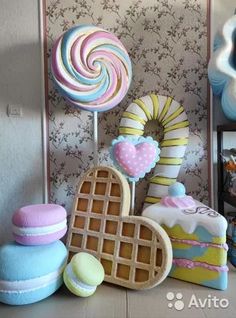 there are many different candies and cakes on the table together in this room with wallpaper