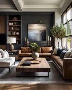 a living room filled with lots of furniture and large windows in the wall behind it