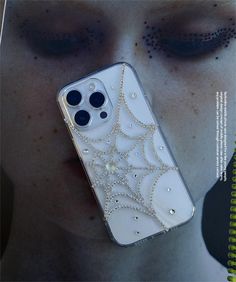 a woman's face with her eyes closed and an iphone case in the shape of a spider web