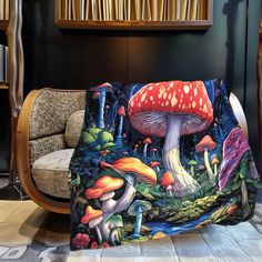 a mushroom print blanket sitting on top of a couch in front of a book shelf