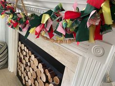 a fire place filled with lots of wooden slices next to a mantle covered in ribbons