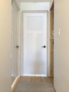 an empty hallway leading to a white door