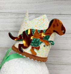 a hat with a dachshund design on it's top and green ribbon around the bottom