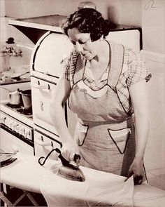 an old photo of a woman in the kitchen