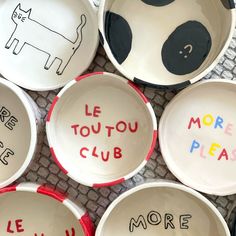 bowls with words written in different languages and pictures on the inside, including one that says more please