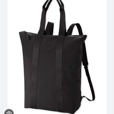 a black tote bag with straps on the front and side, sitting against a white background