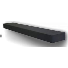 a large black shelf sitting on top of a white wall next to a remote control