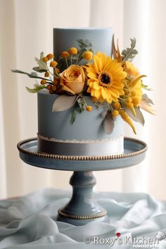 there is a blue cake with yellow flowers on it