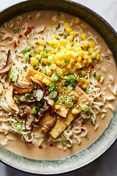 a bowl filled with noodles and vegetables on top of a table