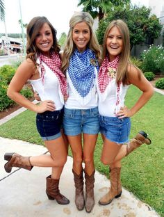 three beautiful young women standing next to each other in cowboy boots and bandana scarves