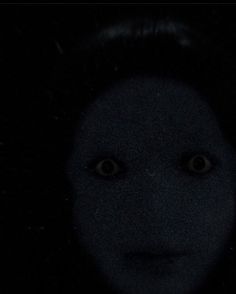 the face of a person with black hair and eyes is shown in the dark night