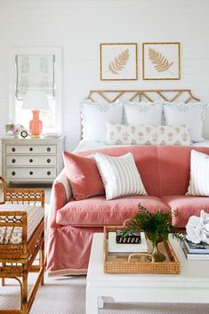 a living room filled with furniture and pillows on top of a white table in front of a window