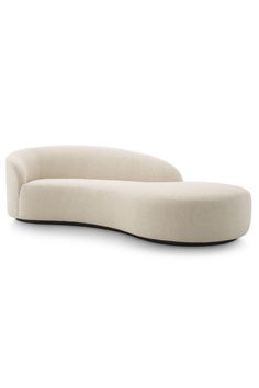 the curved sofa is made out of fabric and has a rounded backrest, with an extended