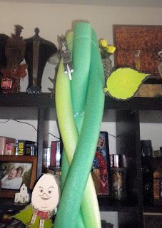 there is a green sculpture in the middle of a room with many bookshelves