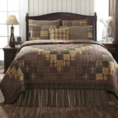 a bed in a bedroom with brown and tan plaid bedspread on top of it