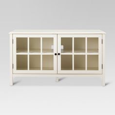 a white entertainment center with glass doors on the front and bottom shelves in different sizes